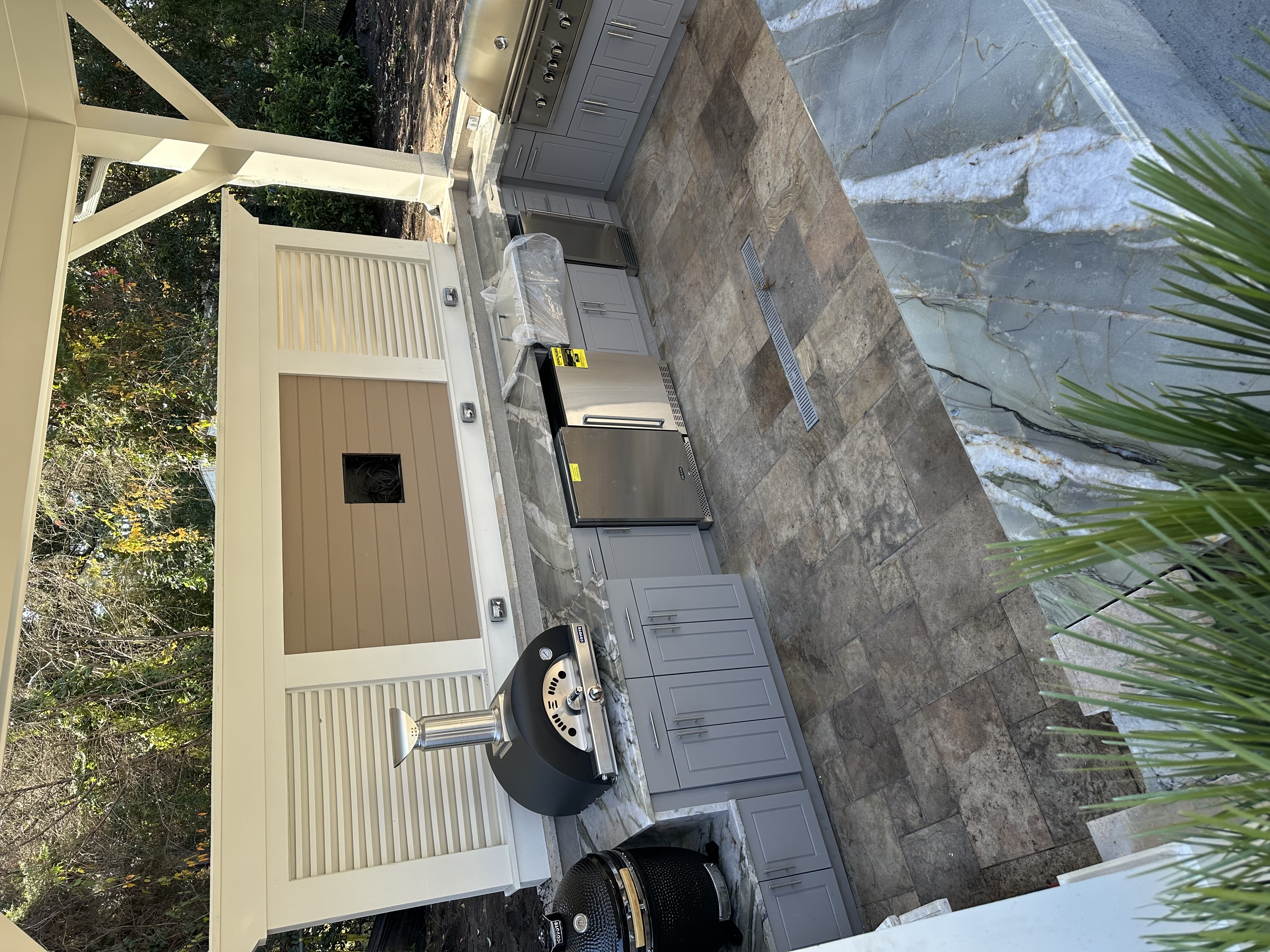Covered outdoor kitchen pavilion with pizza oven and Kamado grill